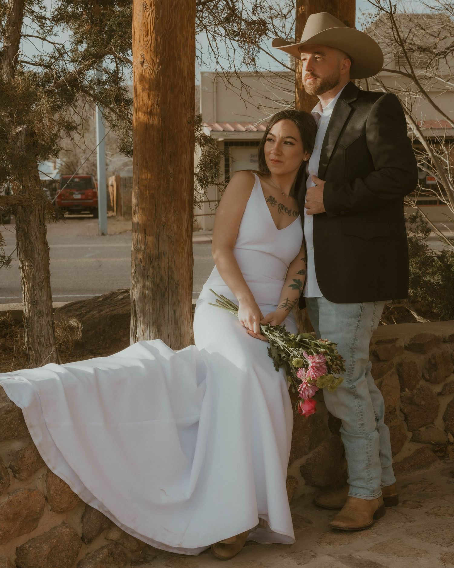 Rustic wedding photos taken against wooden pillars and stone walls.