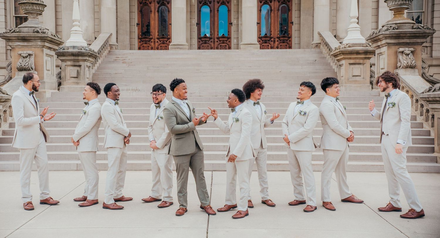 Wedding party in light colored suits and dresses creates a fun panoramic sequence of dance moves on stone steps.