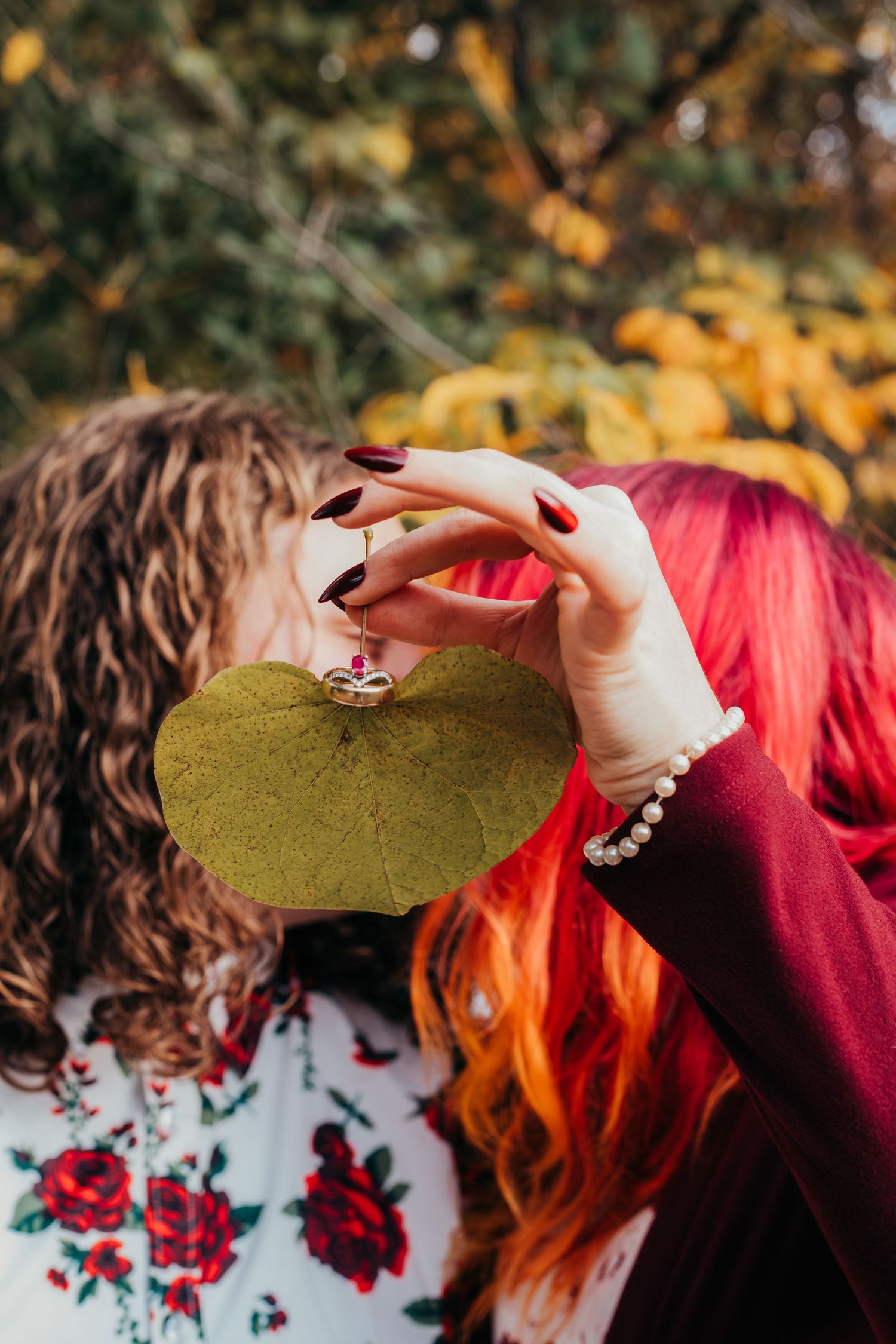 Close-up detail shots of hands with rings against floral fabric and autumn foliage background.