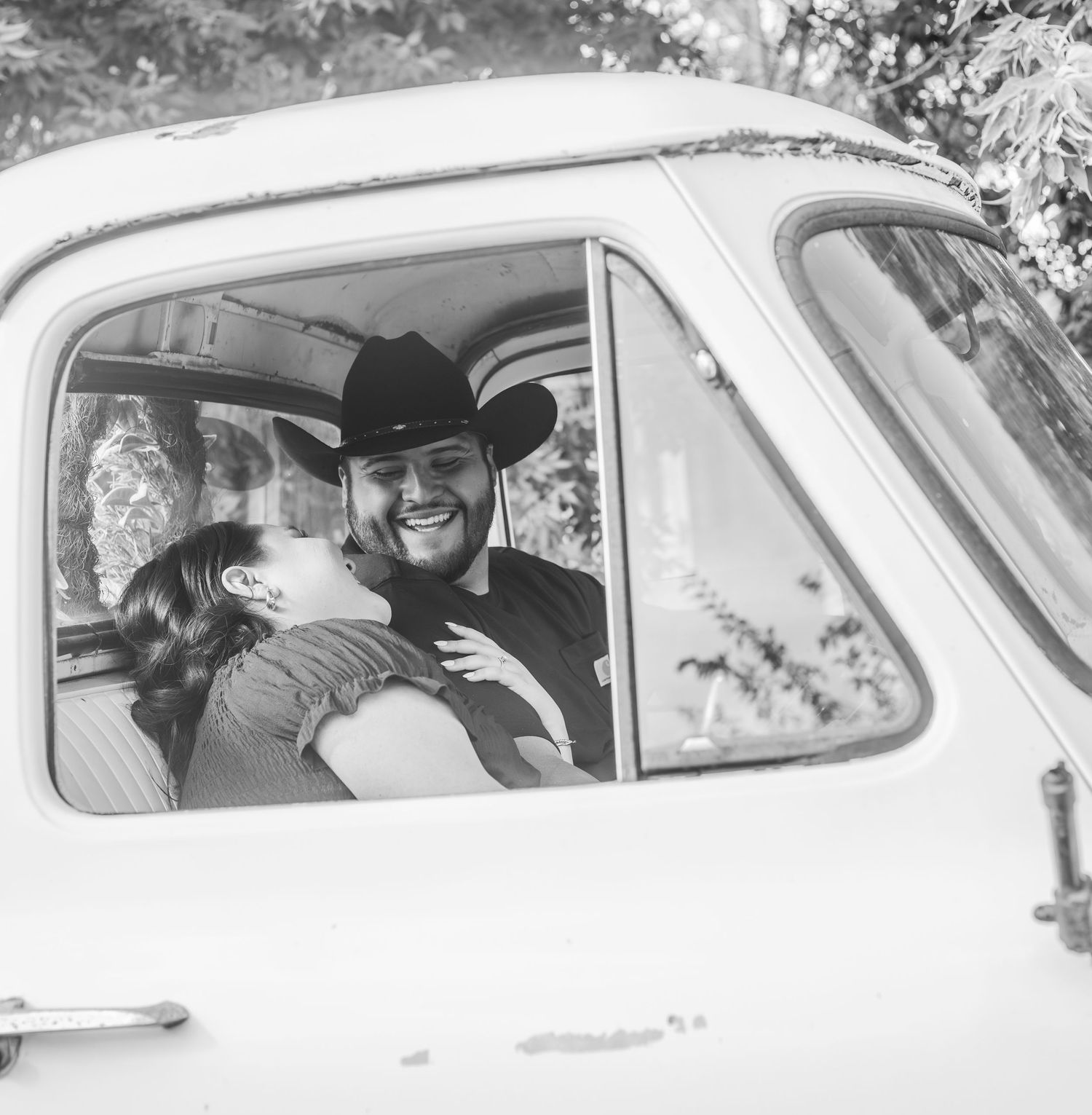 A black and white photo sequence showing a couple kissing through car windows in a romantic vintage moment.