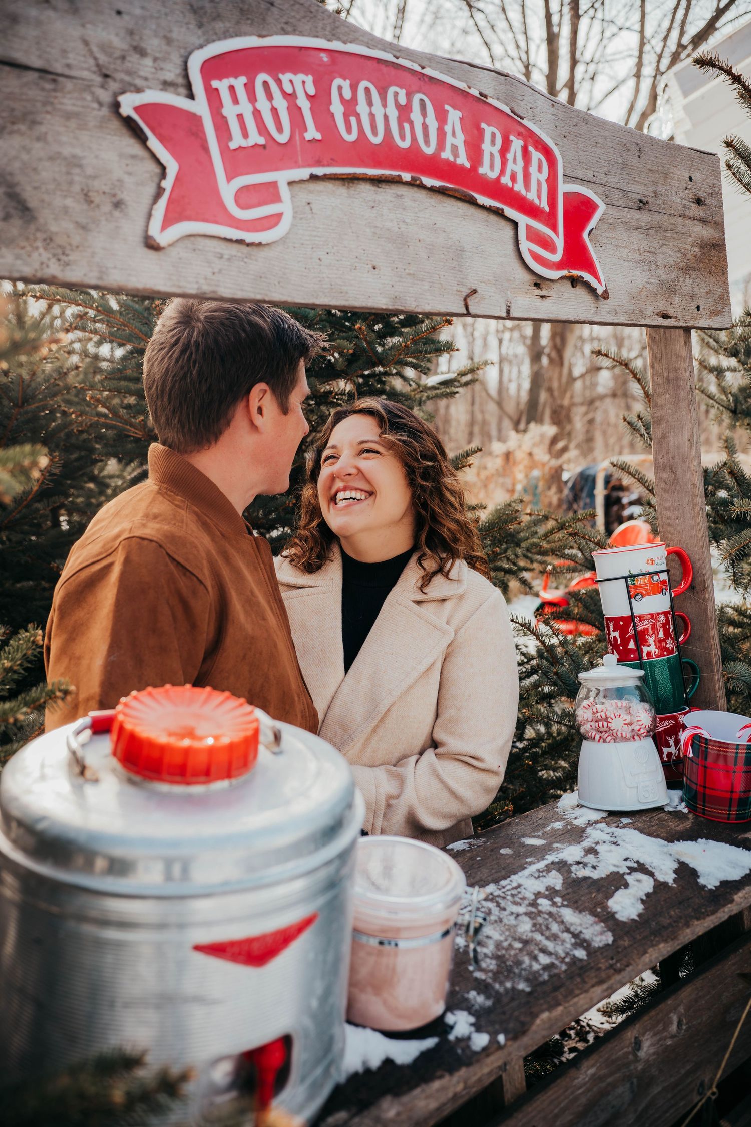 A romantic winter scene at a rustic hot cocoa bar with cozy decor and snowy outdoor seating.