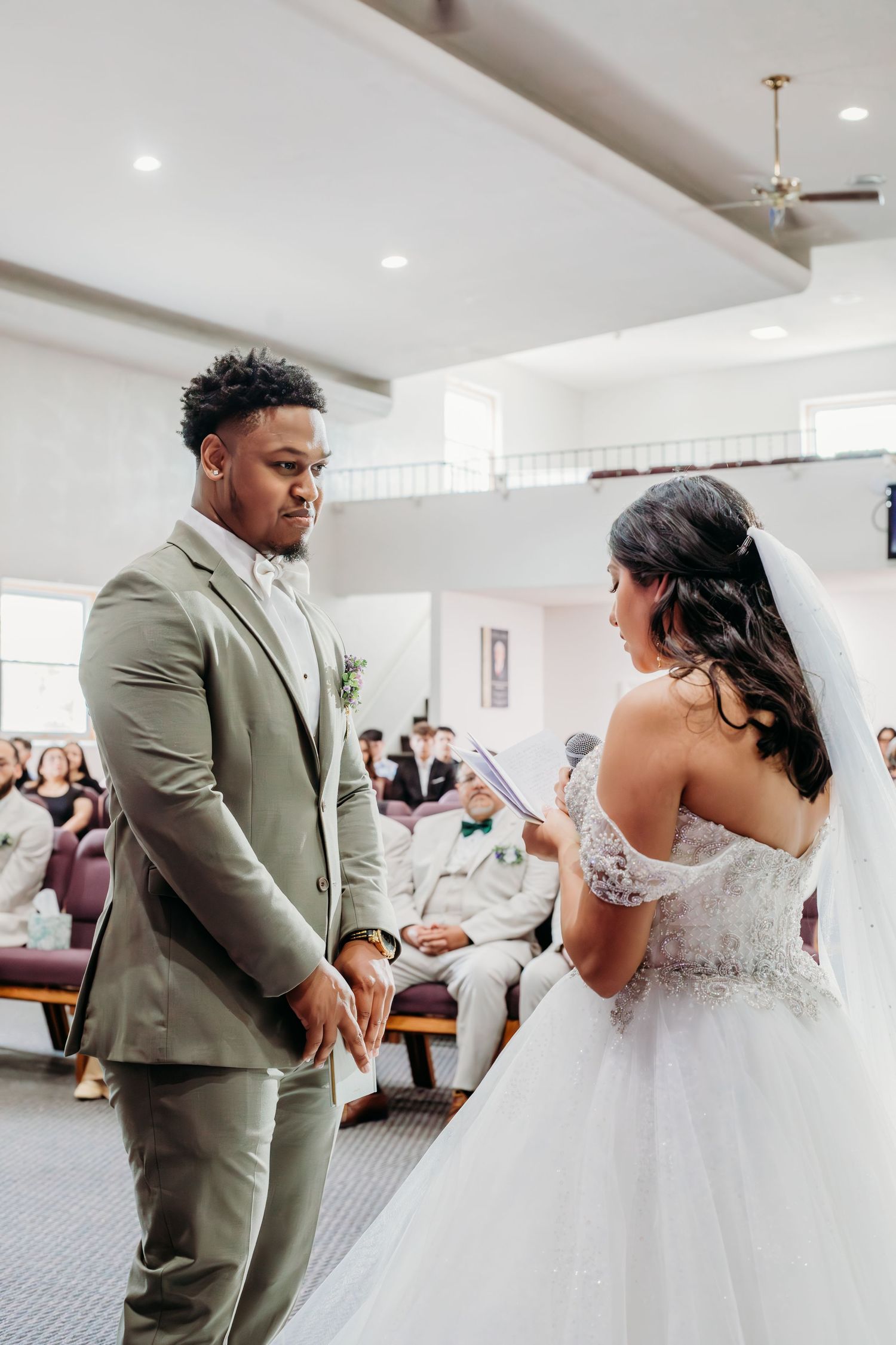 A couple shares an emotional first dance moment at their wedding reception in a bright modern venue.