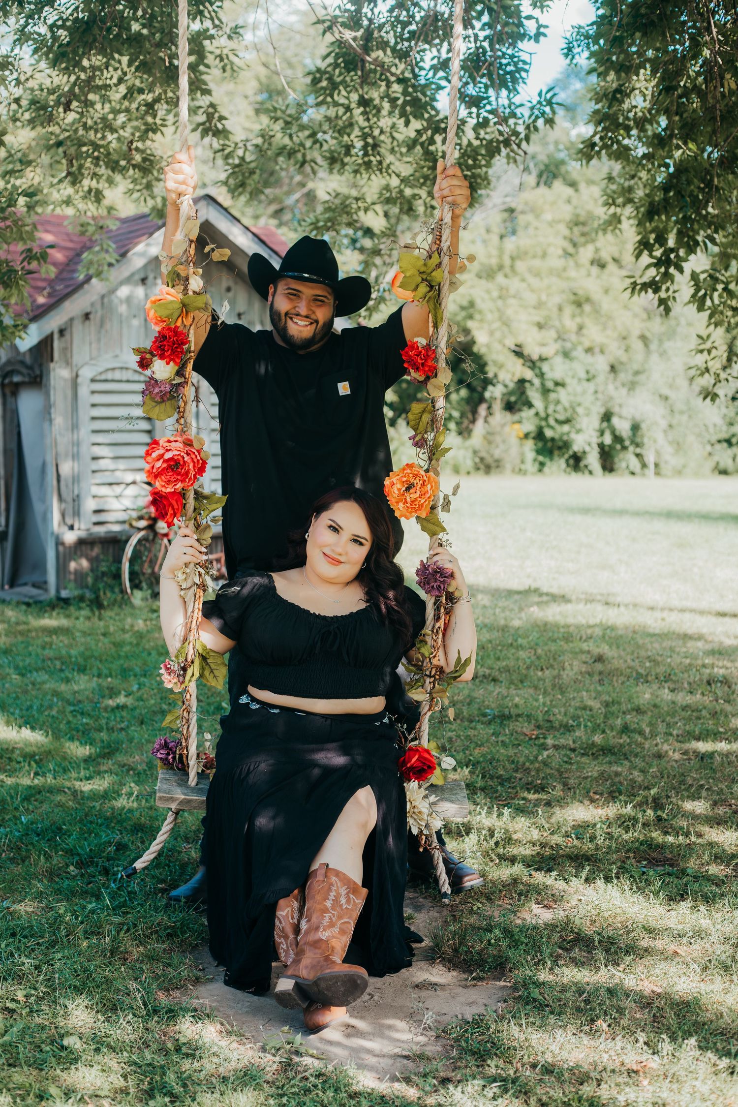 A series of outdoor portraits featuring people in black attire posing with a decorative floral arch in a natural setting.