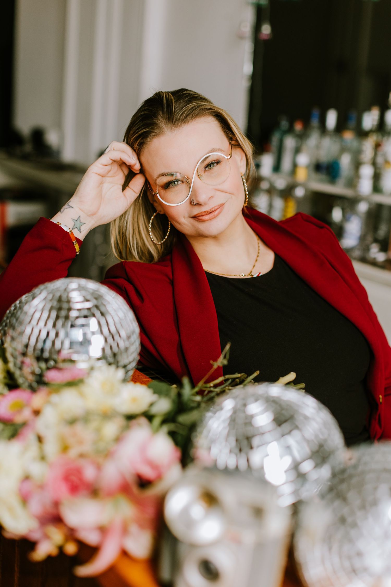 A series of candid shots showing someone in a red sweater relaxing at a table with floral arrangements and disco balls.