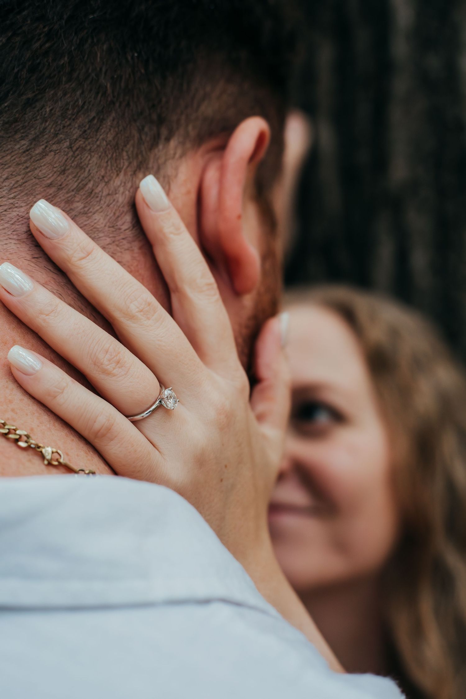 A romantic engagement photo series showing close-up shots of hands with rings and an intimate embrace.