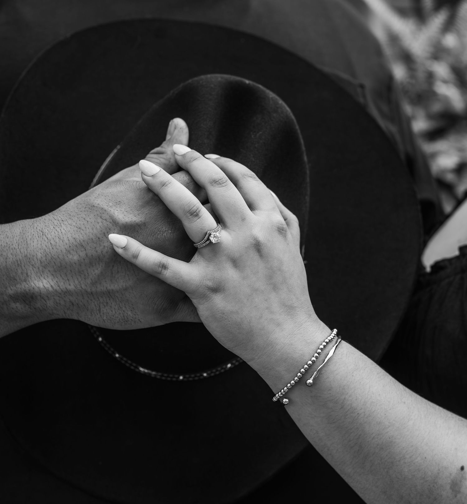 Black and white close-up photo of hands playing cymbals in a drum set.