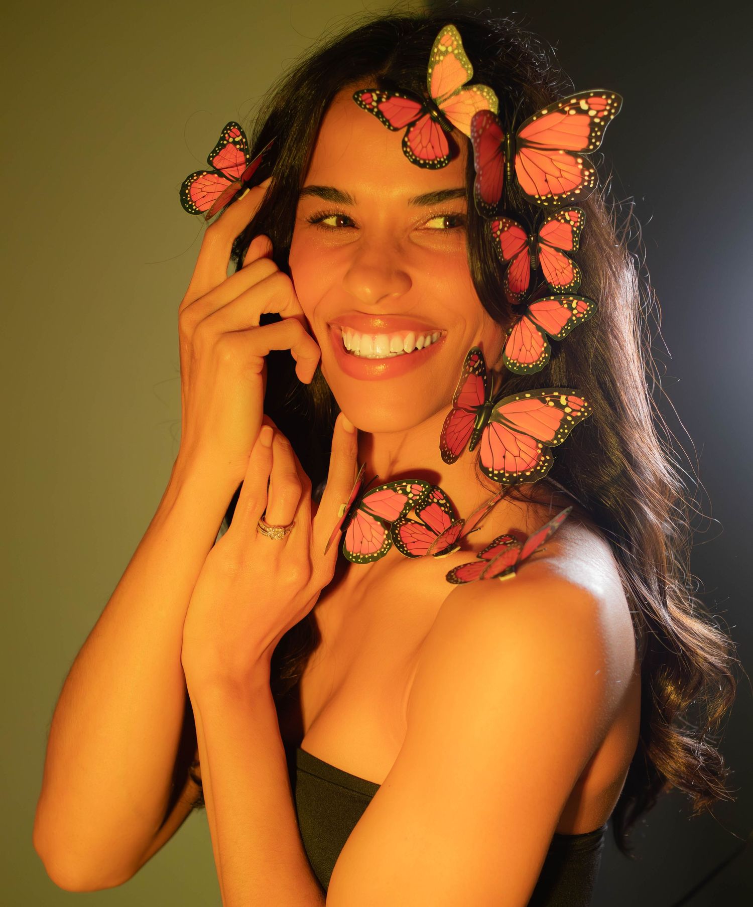 A creative photo series showing monarch butterflies decorating a portrait in warm lighting.