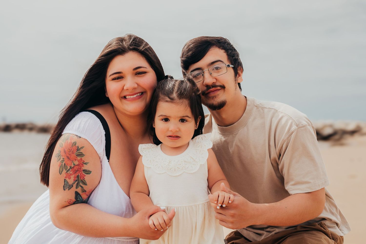 A family enjoys a relaxed moment together at the beach during sunset.