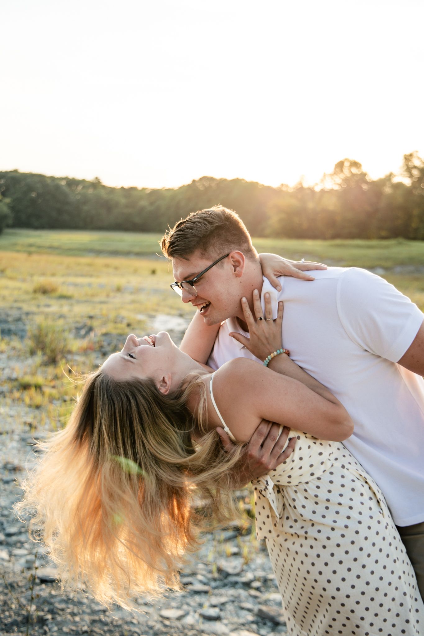 light and airy photo of a couple in a field laughing
