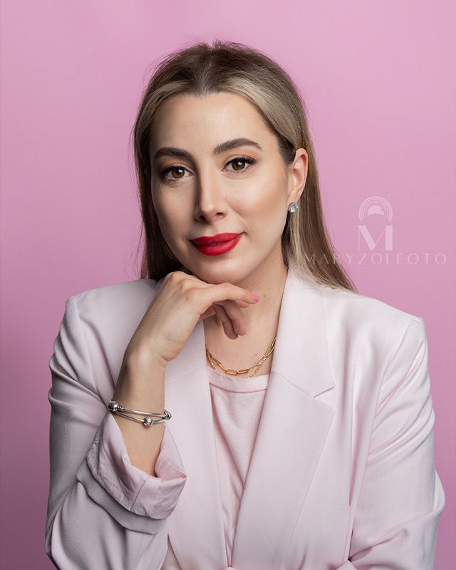 Retrato de estudio de mujer de negocios, usando saco rosa y blusa rosa.