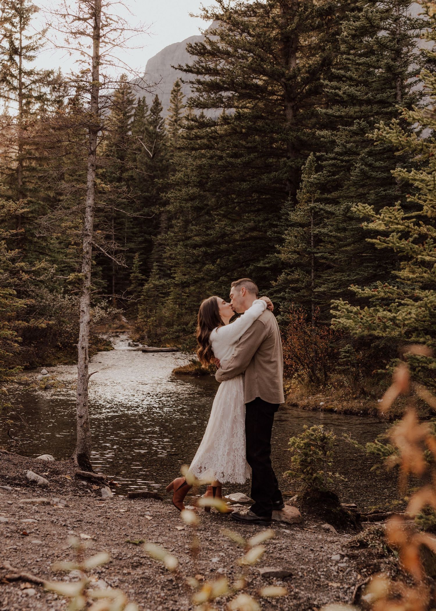 Dancing together among evergreen trees in a mountain setting.