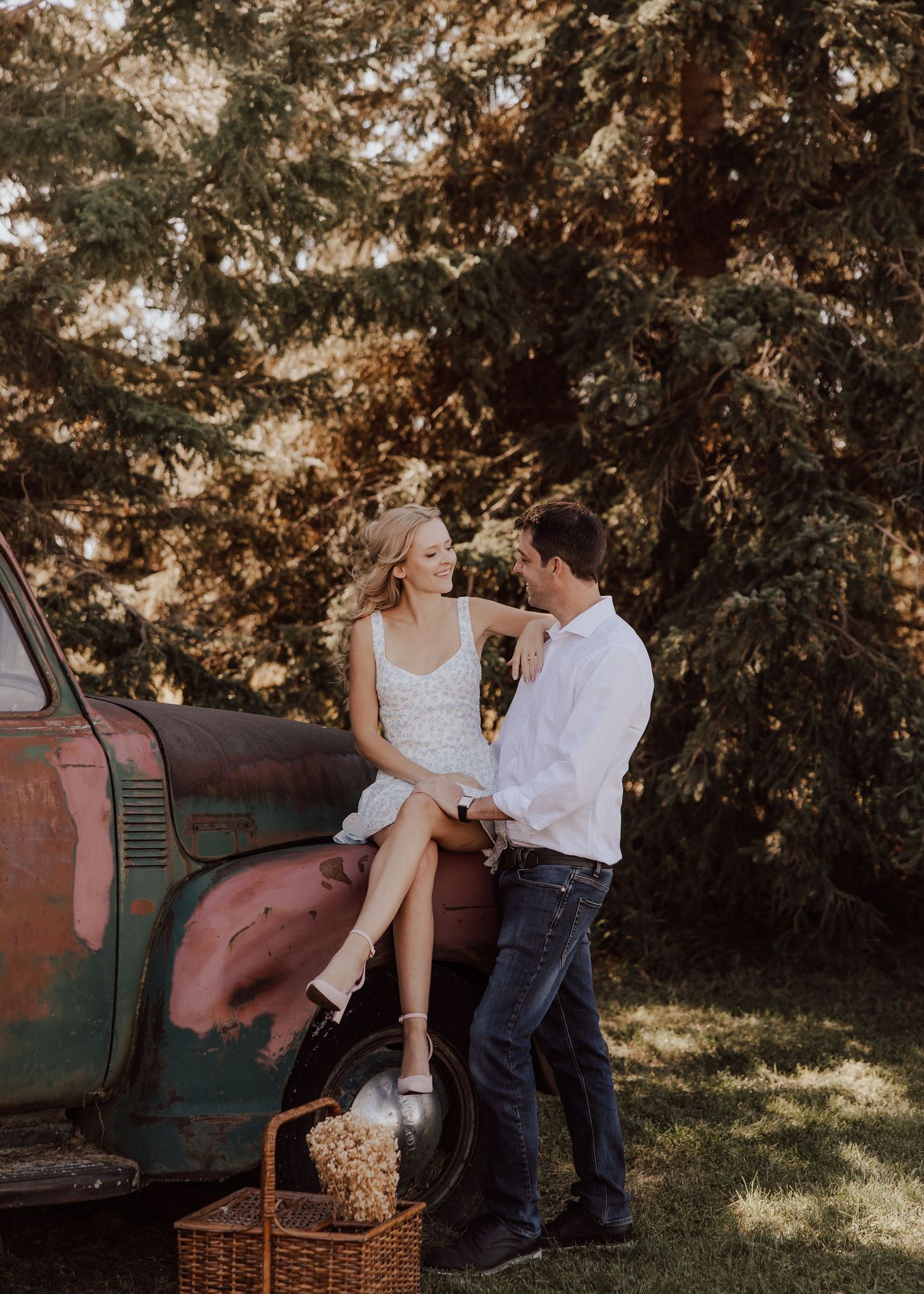 A romantic photoshoot by a vintage truck with rustic baskets and natural scenery.
