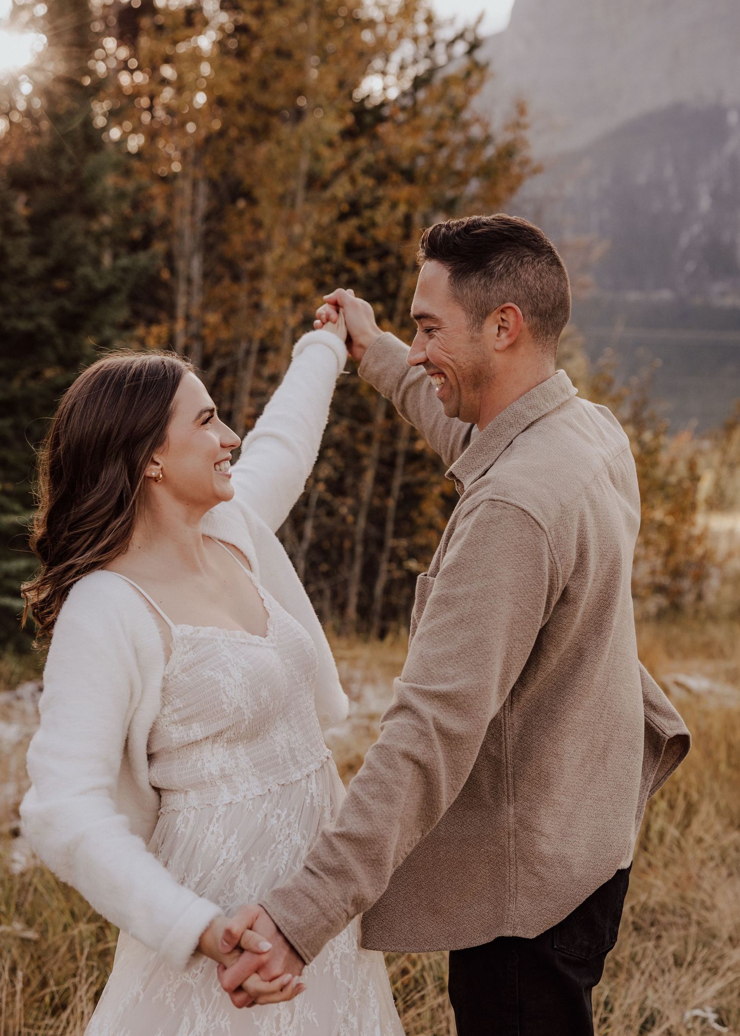 A couple sharing a playful dance moment in golden autumn light.