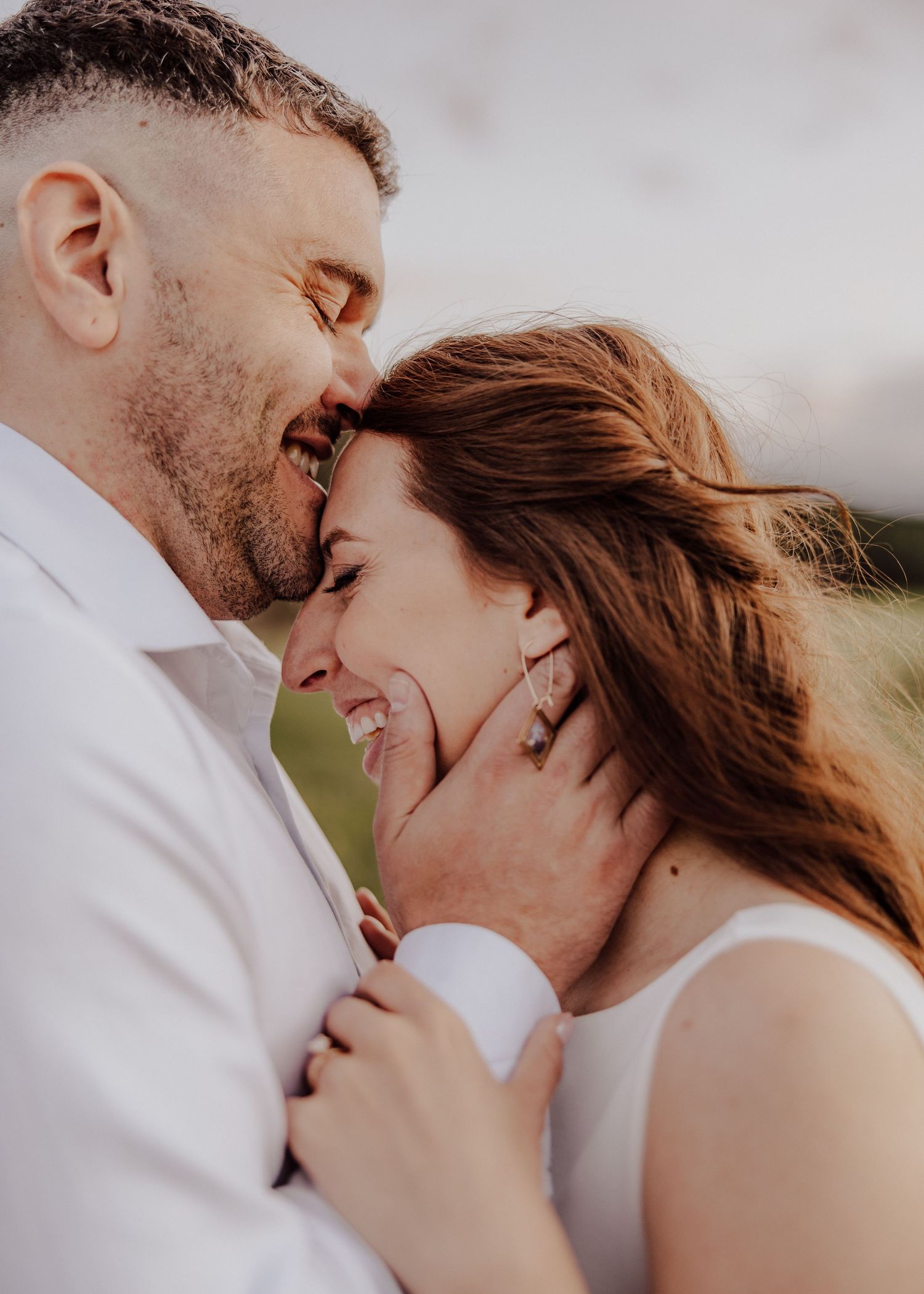 A romantic couple shares intimate moments in a series of close-up shots against a cloudy sky background.