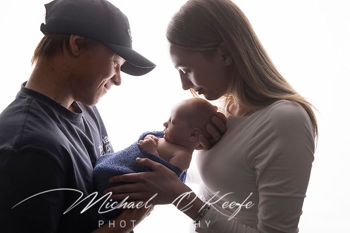 A series of intimate maternity photos showing couples embracing and touching a pregnant belly in soft lighting.