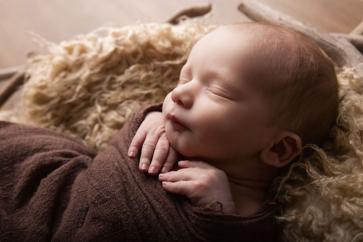 A collection of intimate close-up photos showing a sleeping baby on soft beige fur blankets.