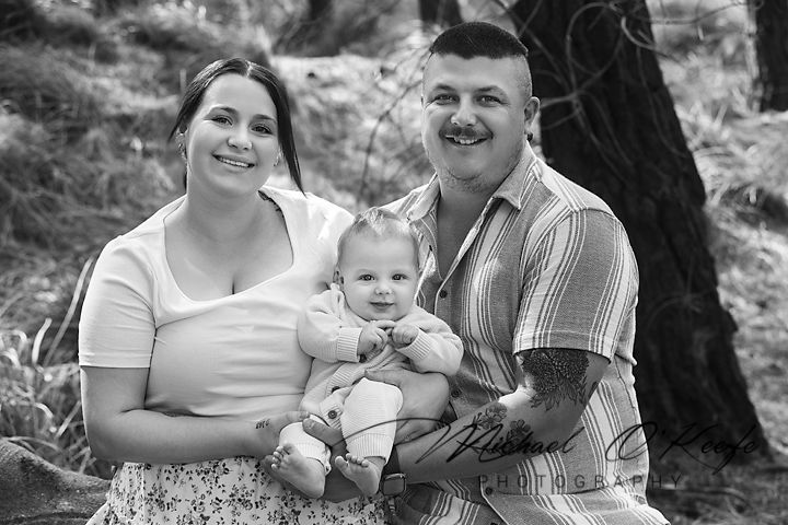 A black and white photo collage showing candid family moments outdoors with natural scenery in the background.
