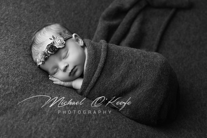 A series of black and white newborn baby photographs showing gentle poses and sleeping details.