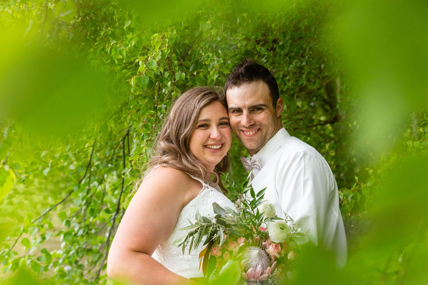 Wedding portraits framed by vibrant green foliage showing intimate moments between newlyweds.
