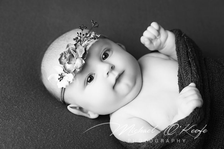 A black and white artistic photo series showing different angles of a baby in a minimalist style.