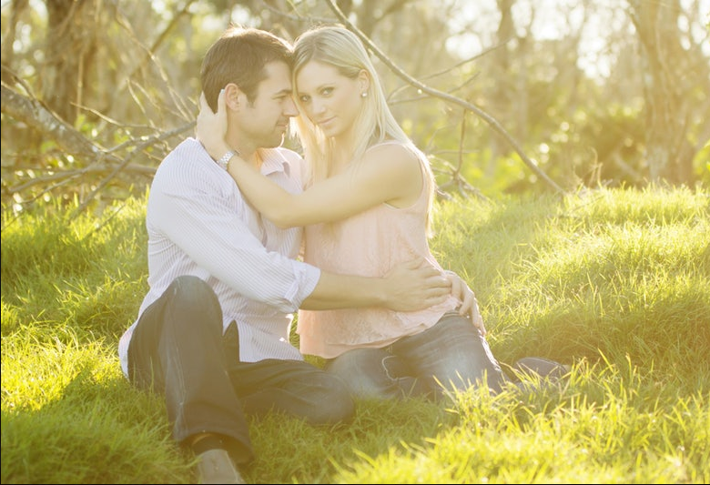 Golden hour outdoor family photoshoot with warm sunlight filtering through trees.