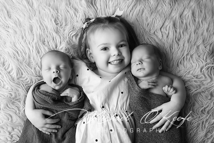 Black and white photo series showing a baby lying on textured fabric in different candid poses and expressions.
