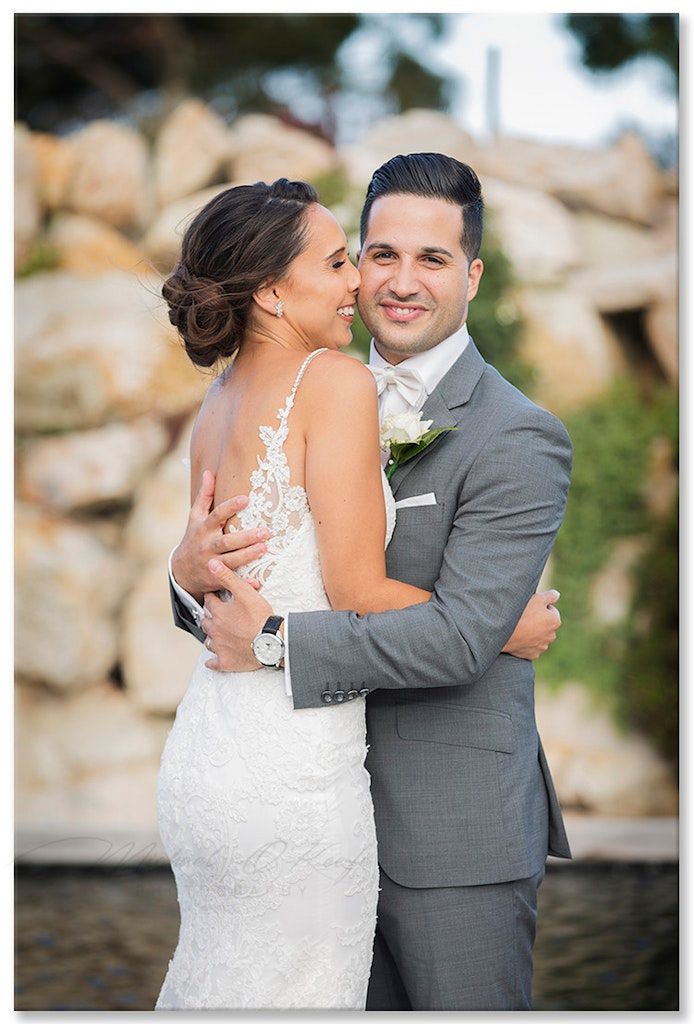Wedding portraits showcasing tender moments between newlyweds against a stone backdrop.