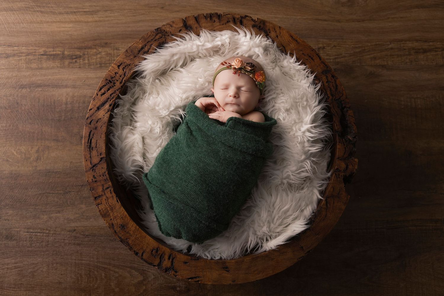 A series of five wooden bowls with white fur lining showing a newborn photography setup on a dark wood background.
