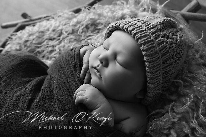 A series of black and white artistic maternity portraits showing a pregnant woman resting peacefully on white fabric.
