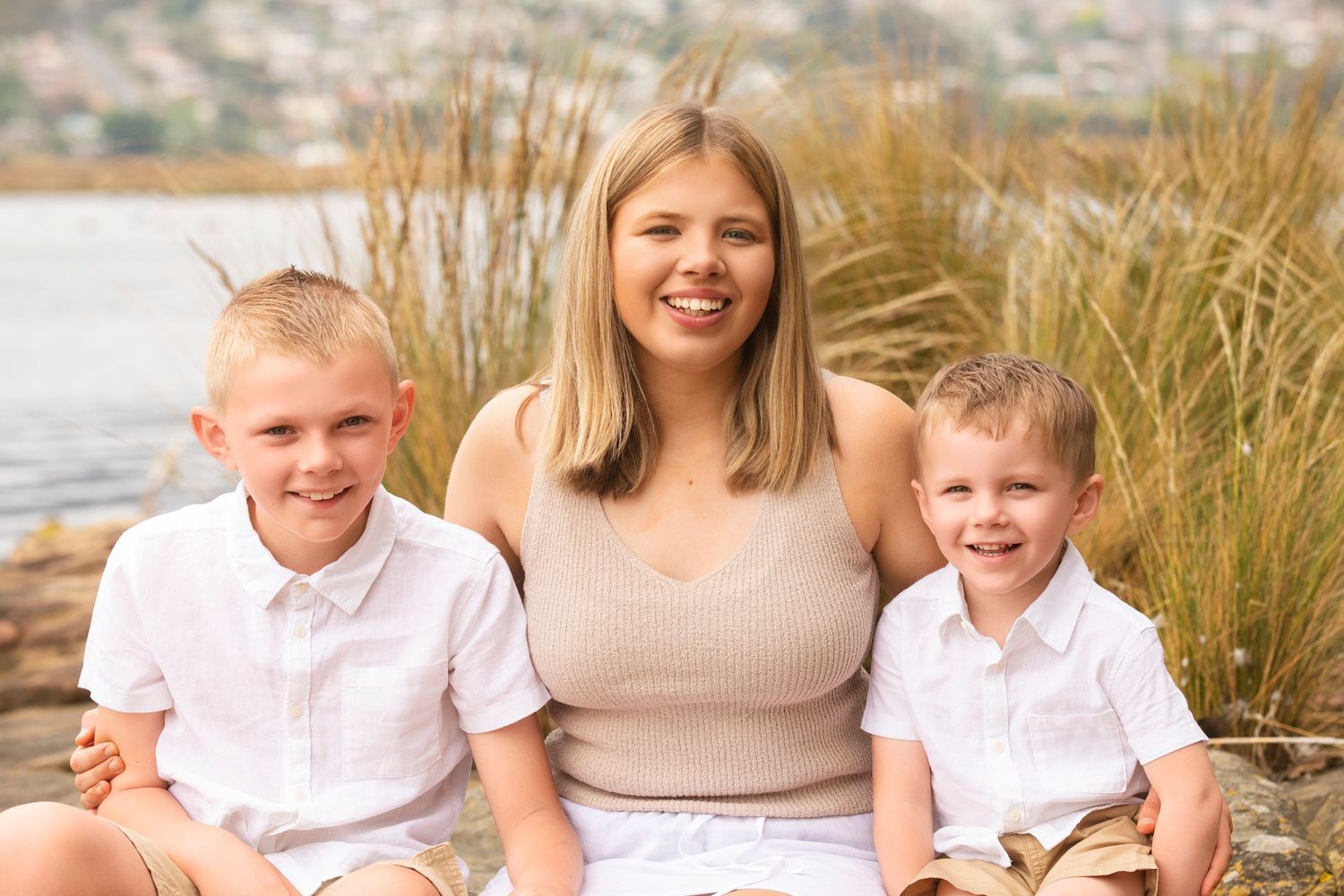 Family enjoys moments together on beach trail with coastal views in background.