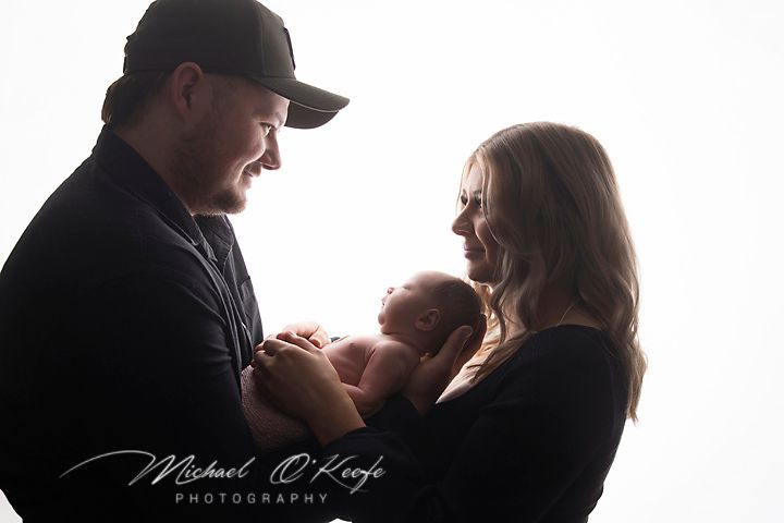 Dramatic silhouette series capturing tender family moments in black and white.