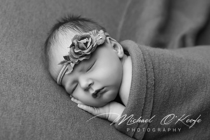 Black and white newborn portrait series showing sleeping baby with soft textures.