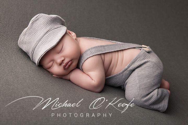 A series of five artistic black and white newborn photography poses on a soft grey backdrop.