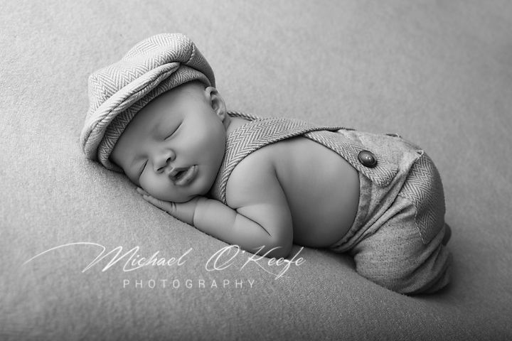 Black and white artistic photo series of a sleeping newborn baby in various peaceful poses on soft textured blankets.