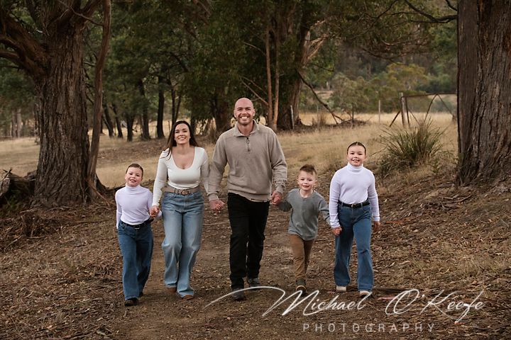 Panoramic family portrait in woodland setting with rustic natural elements.