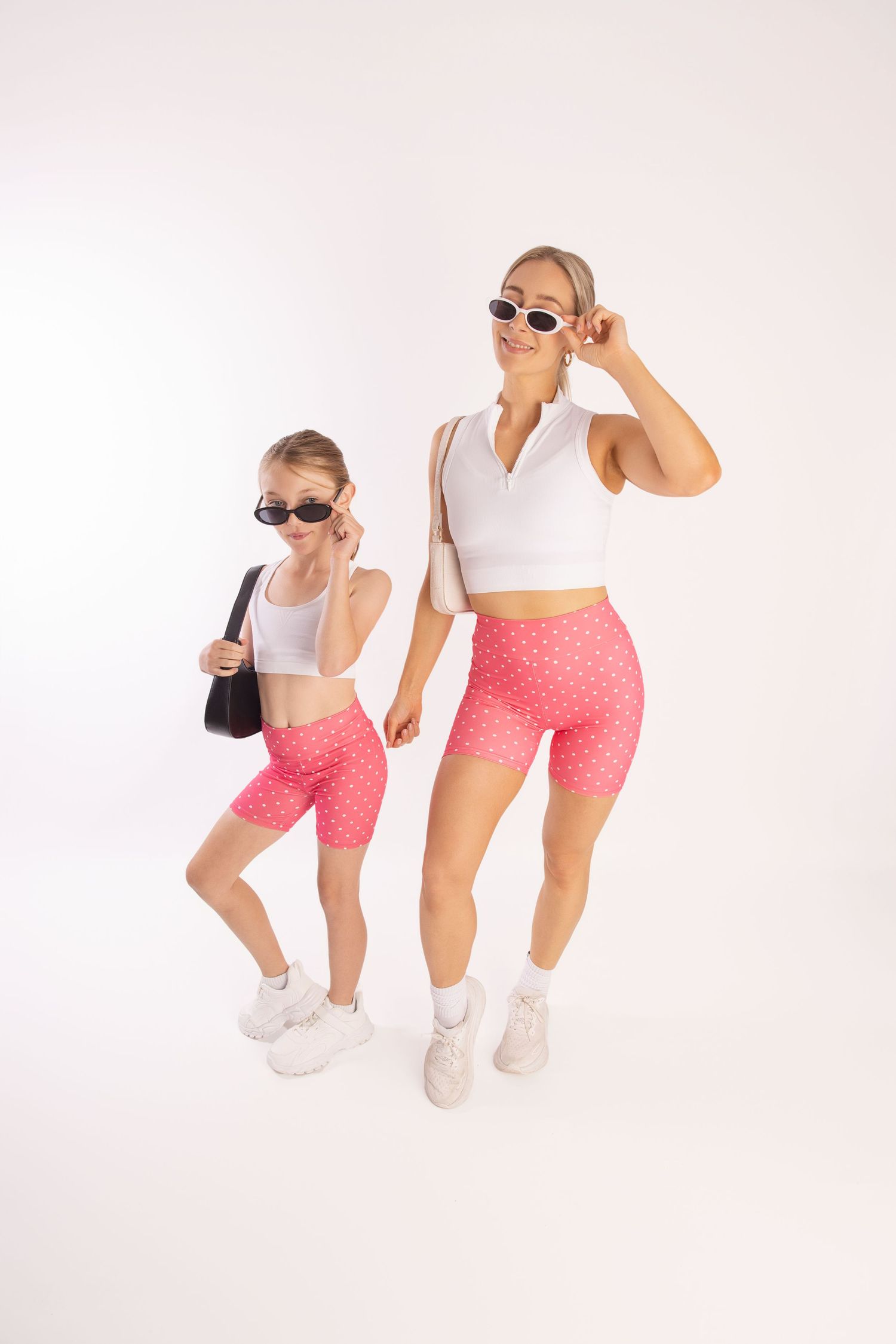 Two people in matching athletic wear and sunglasses pose stylishly against a white background.