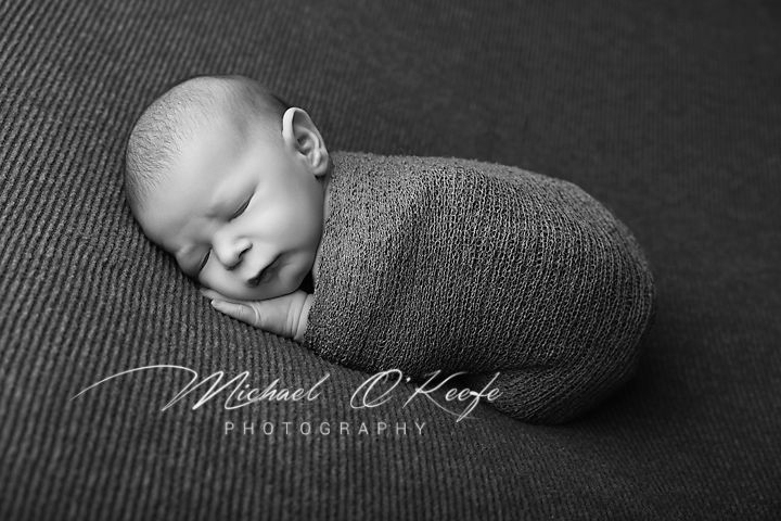 Black and white artistic newborn photography collage showing peaceful sleeping baby in different poses.