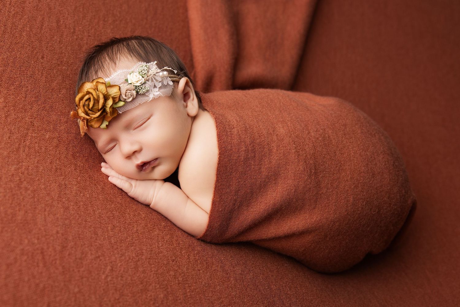 Newborn baby sleeping peacefully on a brown blanket in a series of connected photos.