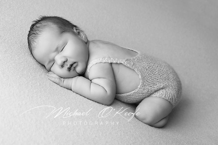 Artistic black and white newborn photography series showing peaceful sleeping baby in various gentle poses.