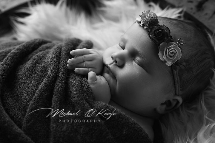 Black and white newborn photography collage showing sleeping baby in various peaceful poses.