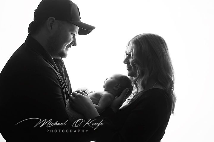 Family silhouettes captured in intimate moments against bright white backdrop.
