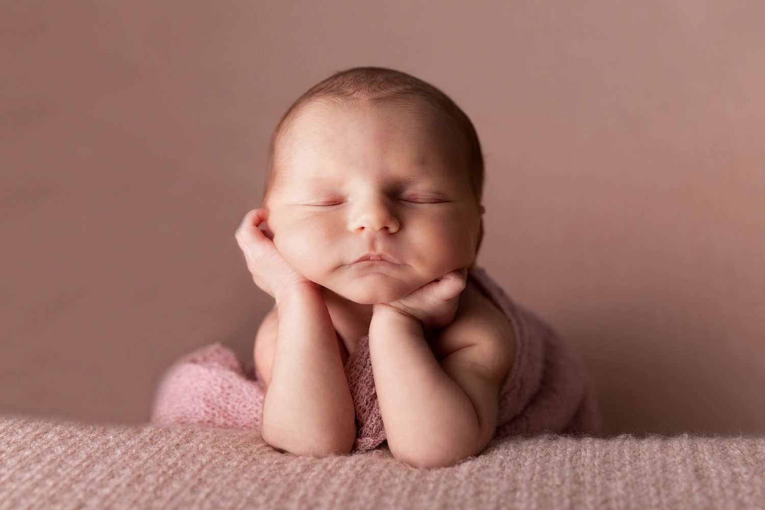 Peaceful newborn portraits on pink backgrounds showing gentle sleeping poses.