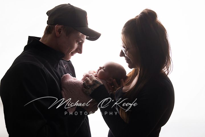 Two people share an intimate silhouette moment backlit with window light in a romantic portrait scene.