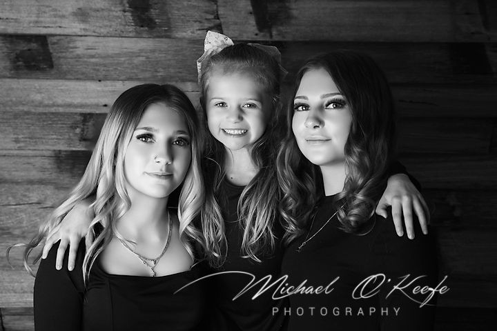 Black and white collage of artistic portrait photos showing multiple poses against a textured wooden wall background.