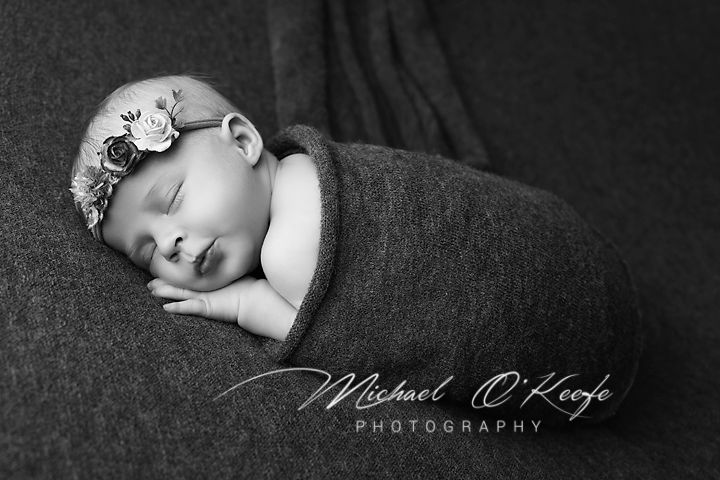 Black and white artistic newborn photography collage showing peaceful sleeping baby in various poses.