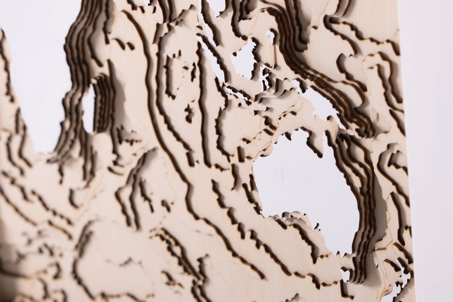 Close-up detail of a textured topographic map pattern carved in wood.