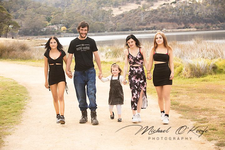Group of people walking together on a scenic outdoor path during golden hour lighting.