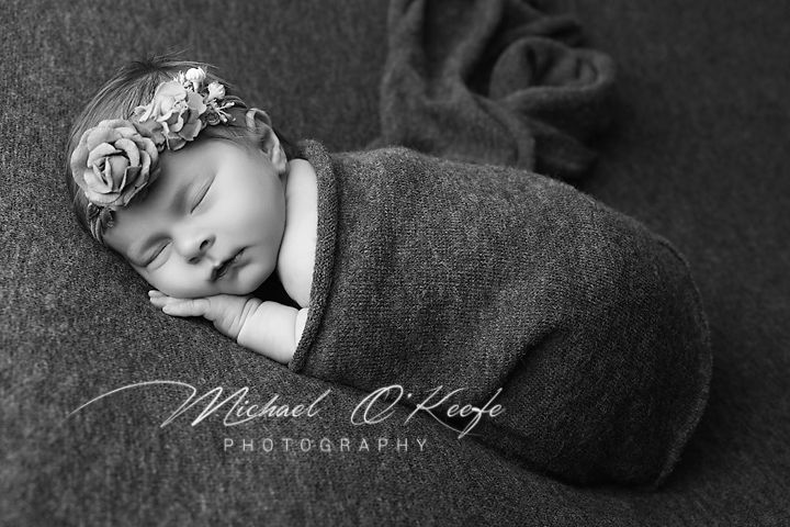 Black and white artistic newborn photography with soft blankets and dreamy lighting.