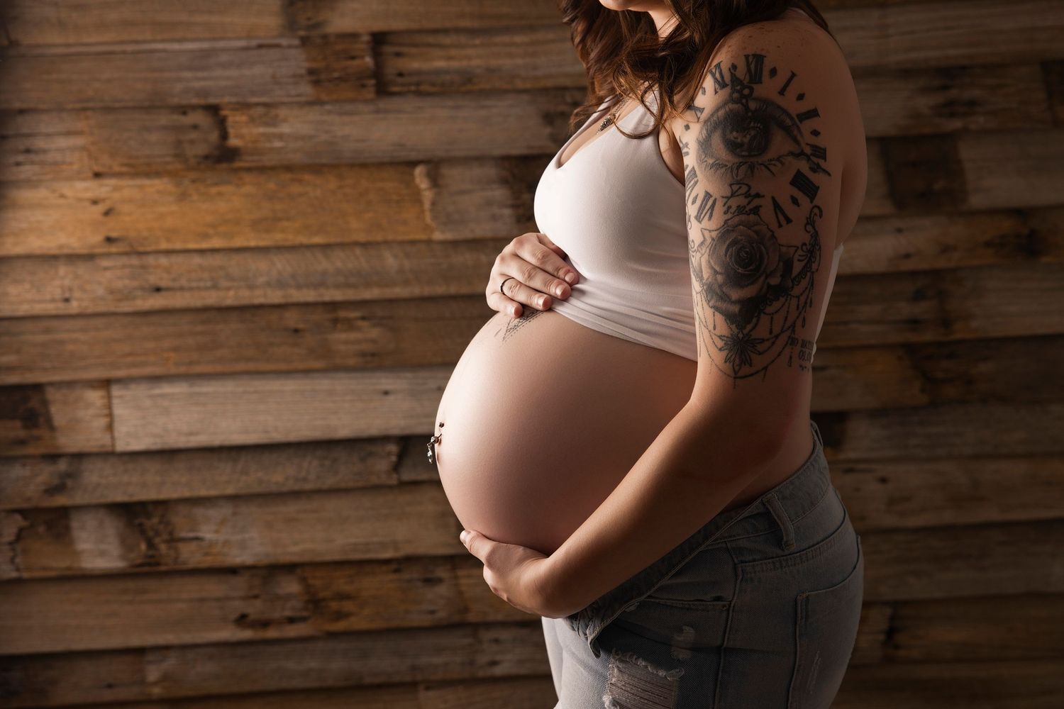 A series of maternity photos showing a pregnant belly against a rustic wooden wall background.