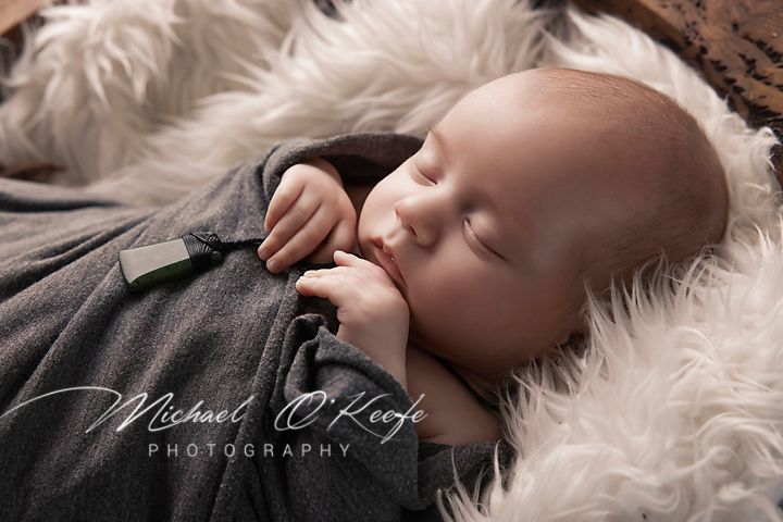 A series of black and white newborn photography portraits showing peaceful sleeping poses on soft white fur.